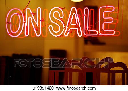 Stock Image - Red neon 'On Sale' sign on the window of a store. Fotosearch