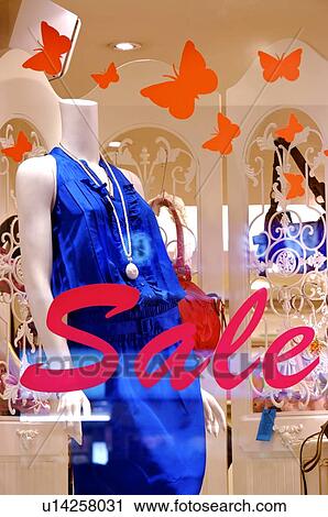 Red 'Sale' sign, and orange butterflies, on the window of a clothing store, with a female mannequin wearing a dress in the window View Large Photo Image Stock Image - Red 'Sale' sign, and orange butterflies, on the window of a clothing store, with a female mannequin wearing a dress in the window. Fotosearch