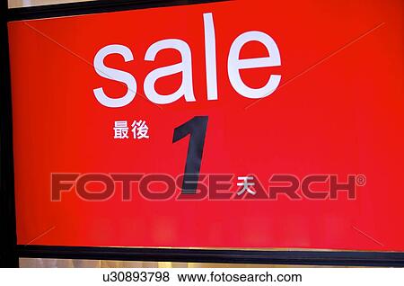 Stock Photo - Red 'Sale' sign with Chinese text, close-up. Fotosearch