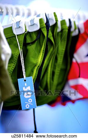 Row of green underwear on a clothes rack, with a discount sign hanging from an underwear View Large Photo Image Picture - Row of green underwear on a clothes rack, with a discount sign hanging from an underwear. Fotosearch