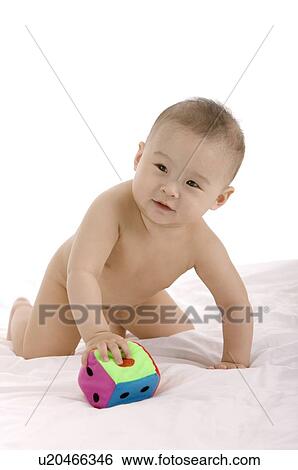 Stock Photograph - Baby boy playing with a soft toy dice. Fotosearch