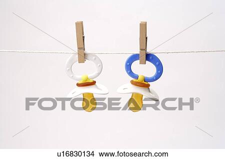 Colorful baby pacifiers hanging by clothespins on a clothesline View Large Photo Image Picture - Colorful baby pacifiers hanging by clothespins on a clothesline. Fotosearch