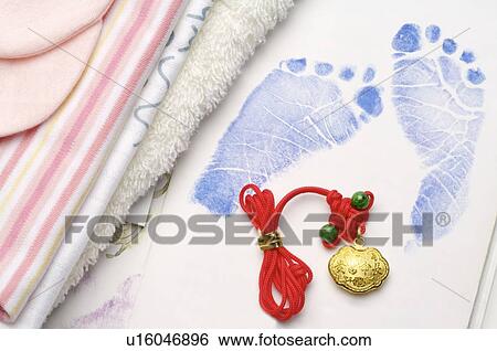 Stock Photograph - Gold lucky charm lying on a picture book, next to towels. Fotosearch