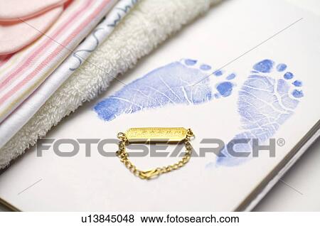 Gold lucky charm next to an baby's footprint View Large Photo Image Stock Photo - Gold lucky charm next to an baby's footprint. Fotosearch