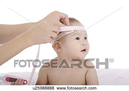 Stock Photo - Mother measuring the head of a baby holding a thermometer, with a tape measure. Fotosearch
