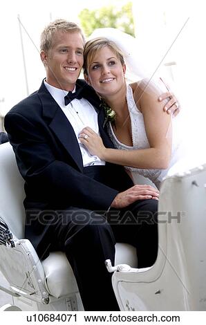 Stock Image - Bride and groom on horse and carriage ride. Fotosearch