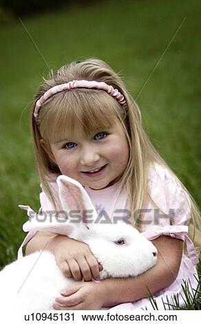 Girl holding bunny View Large Photo Image Stock Image - Girl holding bunny. Fotosearch