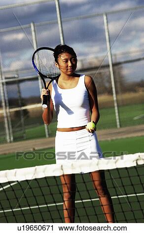 Stock Image - Asian woman playing tennis. Fotosearch