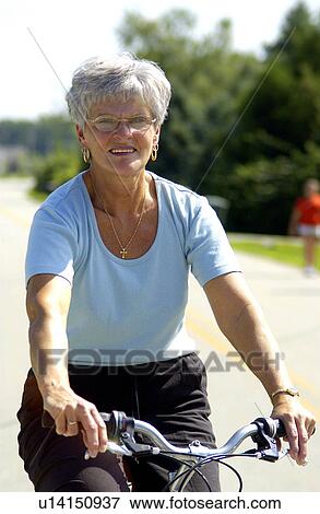 Stock Photo - Senior woman riding bicycle. Fotosearch