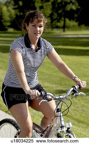 Stock Photography - Woman riding bicycle. Fotosearch