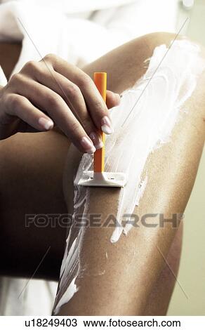 Stock Image - Woman shaving her legs. Fotosearch