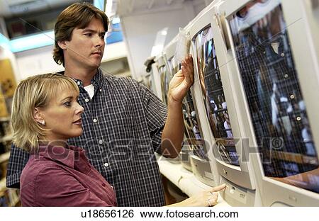 Stock Photograph - Couple looking at televisions. Fotosearch
