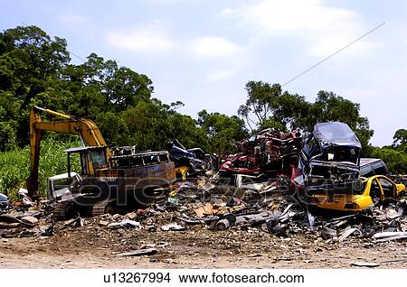 Excavator digging at run-down automobiles in a junkyard View Large Photo Image Picture - Excavator digging at run-down automobiles in a junkyard. Fotosearch
