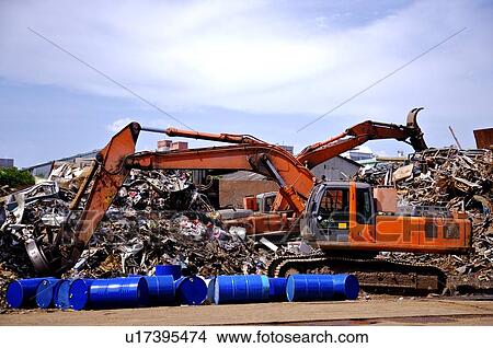 Excavators digging into piles of junk at a junkyard View Large Photo Image Picture - Excavators digging into piles of junk at a junkyard. Fotosearch
