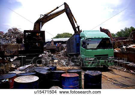 Picture - Oil drums and compressed garbage at a junkyard. Fotosearch