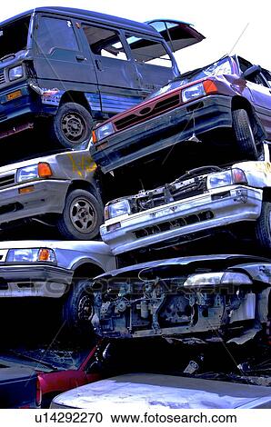 Stock Image - Old cars stacked together in a junkyard. Fotosearch
