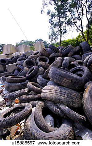 Stock Photo - Pile of used car tires, outdoors. Fotosearch