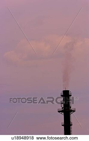 Stock Photo - Smoke, coming out from a large industrial chimney into the sky. Fotosearch