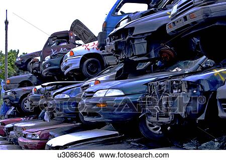 Stock Photograph - Stacks of run-down cars at a junkyard. Fotosearch