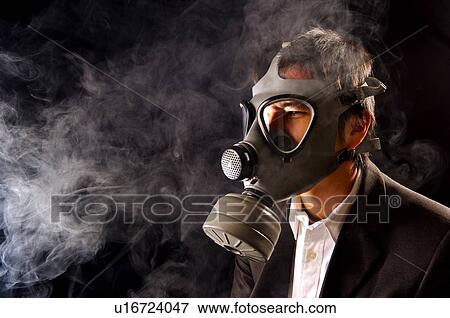 Stock Photo - Young man wearing a gas mask, protecting himself from smoke. Fotosearch