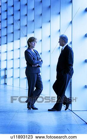 Stock Image - Businessman and businesswoman talking. Fotosearch