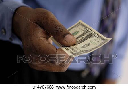 Stock Photo - Businessman holding money. Fotosearch