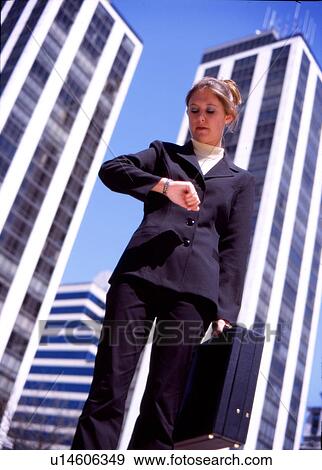 Stock Photo - Businesswoman checking the time. Fotosearch