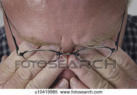 Stock Photography - Senior man rubbing eyes. Fotosearch