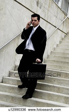 Stock Photograph - Businessman going down set of stairs. Fotosearch