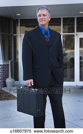 Stock Photography - Businessman in front of building. Fotosearch