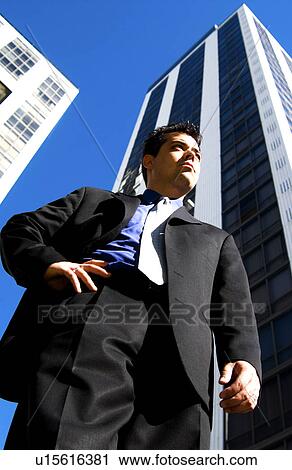 Stock Image - Businessman in front of office building. Fotosearch
