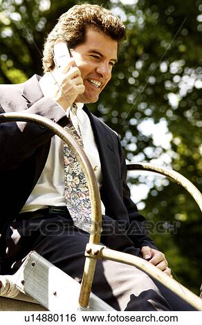 Stock Photograph - Businessman on cell phone on a slide. Fotosearch