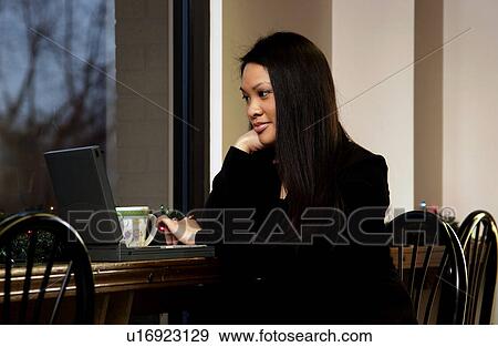 Businesswoman working on laptop in restaurant View Large Photo Image Stock Photo - Businesswoman working on laptop in restaurant. Fotosearch