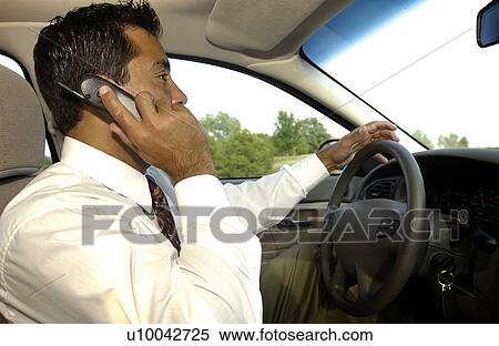 Stock Photography - Man on cell phone driving car. Fotosearch