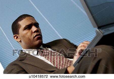 Stock Image - Man working on laptop. Fotosearch