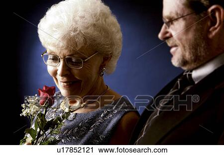 Stock Image - Senior man giving woman a rose. Fotosearch