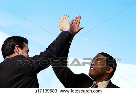 Two businessman giving each other high five View Large Photo Image Stock Image - Two businessman giving each other high five. Fotosearch