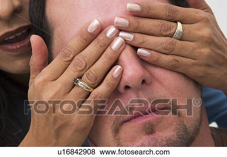 Woman putting her hands over Hispanic mans eyes View Large Photo Image Stock Photo - Woman putting her hands over Hispanic mans eyes. Fotosearch