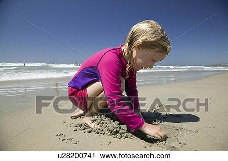 Stock Image - 5 year old girl playing at a beach, San Diego California. Fotosearch