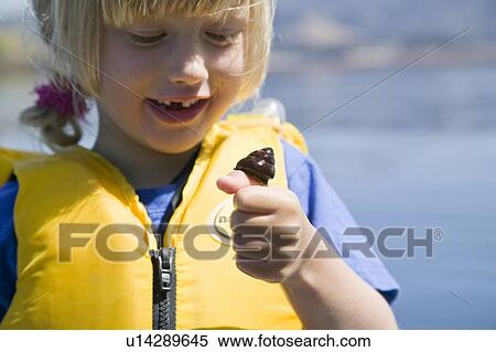 Stock Photography - 5 year old girl with a sea snail, Carmel Bay, California. Fotosearch