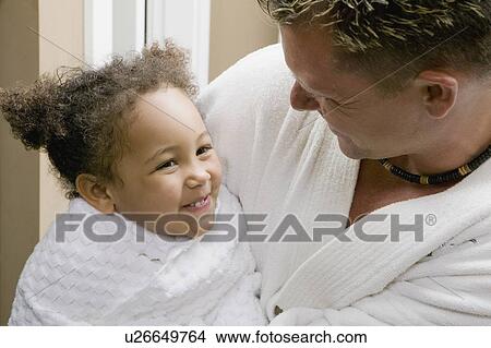 Picture - Caucasian dad snuggling with his 3 year old Mulatto girl.. Fotosearch