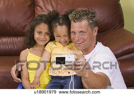 Caucasian father taking picture of self and Mulatto daughters 3 and 6 years old. View Large Photo Image Stock Photo - Caucasian father taking picture of self and Mulatto daughters 3 and 6 years old.. Fotosearch