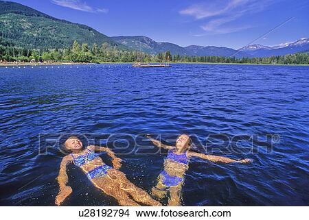 Picture - Girls, 10, float in Alta Lake on a sunny summer day. Fotosearch