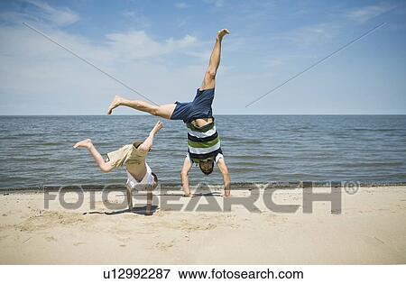 Man and boy (7) doing cartwheels, Grand Beach Provincial Park, Manitoba View Large Photo Image Stock Photo - Man and boy (7) doing cartwheels, Grand Beach Provincial Park, Manitoba. Fotosearch