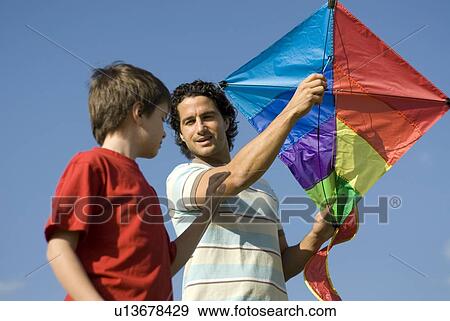 Stock Photo - Six year old boy and father try to fly a kite, Assiniboine Park, Winnipeg, Canada. Fotosearch