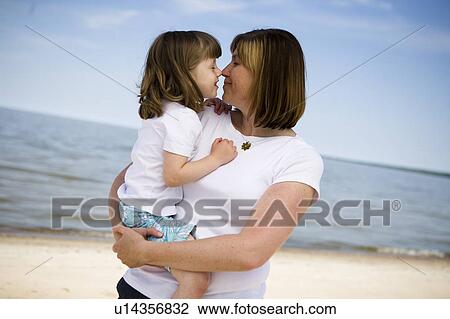 Stock Image - Woman and girl (4), cuddle, Grand Beach Provincial Park, Manitoba, Canada. Fotosearch