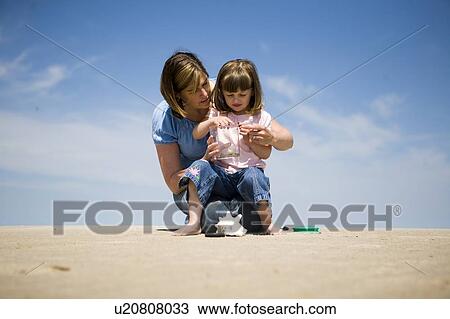 Woman and girl (4) look at ladybugs in collecting jar, Grand Beach Provincial Park, Manitoba, Canada View Large Photo Image Stock Image - Woman and girl (4) look at ladybugs in collecting jar, Grand Beach Provincial Park, Manitoba, Canada. Fotosearch