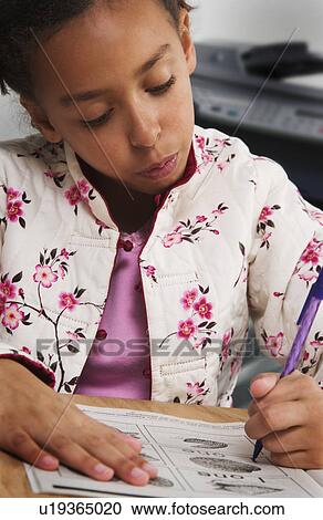Stock Image - African American girl doing homework. Fotosearch