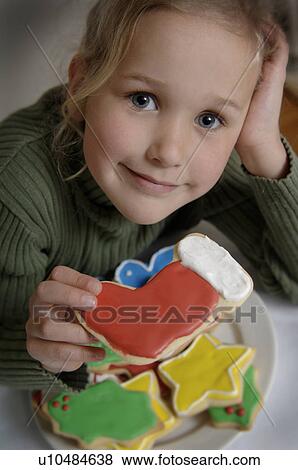 Stock Photo - Girl holding Christmas cookie. Fotosearch