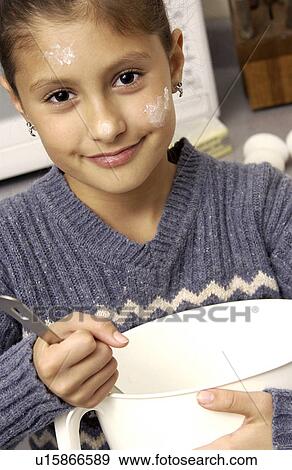 Girl stirring dough in a mixing bowl View Large Photo Image Stock Photo - Girl stirring dough in a mixing bowl. Fotosearch